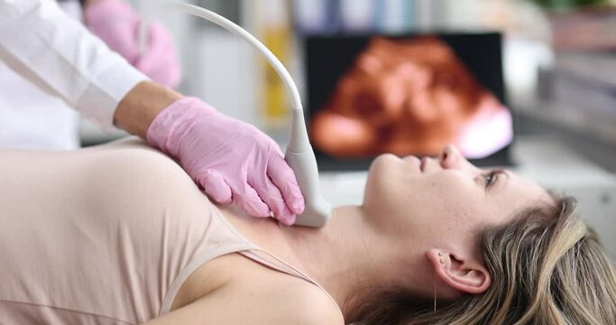 Doctor diagnoses ultrasound of thyroid gland of patient in clinic