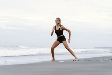 Sporty woman doing mountain climber exercise - run in plank to burn fat. Sunset beach, blue sky...