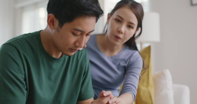 Asia young people stress relief trust talk share suffer cancer pain sick family loss bad news crisis. Sorrow cry man and carer woman sit at sofa home help listen by love hold hand warm hug touch wife.