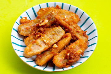 Fried bananas on green background.
