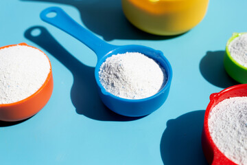 Detergent powder with measuring spoon for clothes washing. Laundry concept.