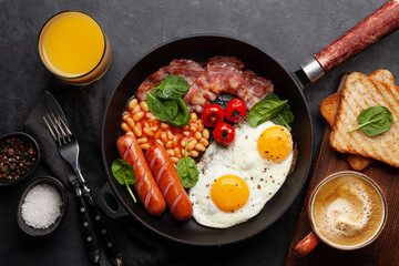 English breakfast with fried eggs, beans, bacon and sausages