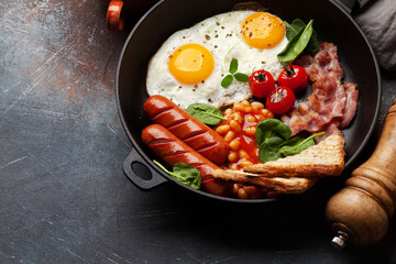 English breakfast with fried eggs, beans, bacon and sausages