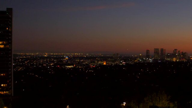 View left to right of Downtown Los Angeles Skyline in USA at dawn. Beautiful colorful sky over the city, sunset fading to night.