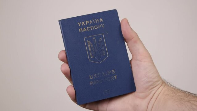 Blue passport of Ukraine male hand holding a document. The concept of tourism, travel, air travel, nationality