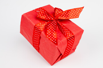 Free floating red gift box with red ribbon isolated on white. Holiday and shopping concept