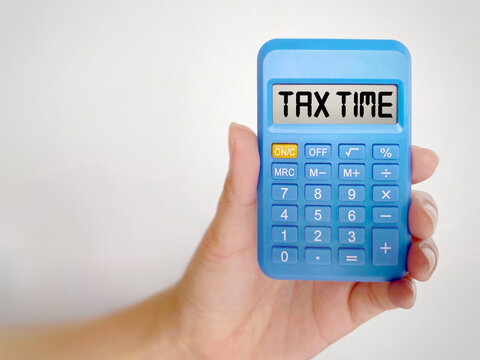 Tax-filling concept - TAX TIME text with white background. Close up front view. Stock photo.