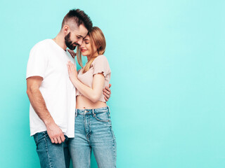Sexy smiling beautiful woman and her handsome boyfriend. Happy cheerful family having tender moments near blue wall in studio.Pure cheerful models hugging.Embracing each other. Cheerful and happy