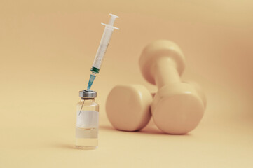 syringe is stuck in a jar, there are dumbbells on a yellow background next to it, a horizontal...