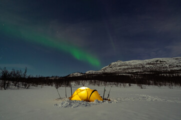 Nothern lights, aurora borealis, above a tent in Swedish Lapland at the famous Kungsleden.