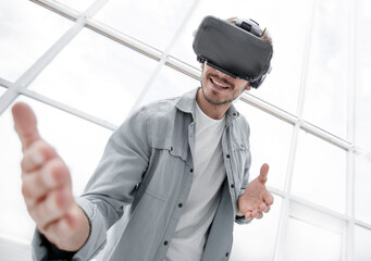 Enjoying new reality. Attractive young man in VR headset gesturi