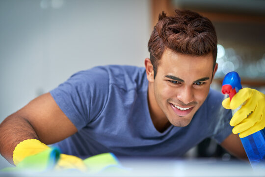 Eager To Clean. Shot Of A Young Man Doing Household Chores.