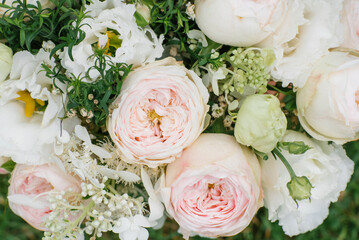 Delicate pink peony-shaped roses close-up in a bouquet for the bride. Floral shop