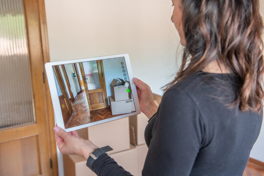 Woman plans on selling her empty studio apartment taking photo of interior in custom design living room on her smart tablet. House seller giving video tour around her home.