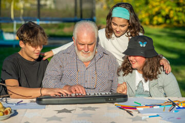 Grandfather explains how to use piano to his grandchildren outdoor.