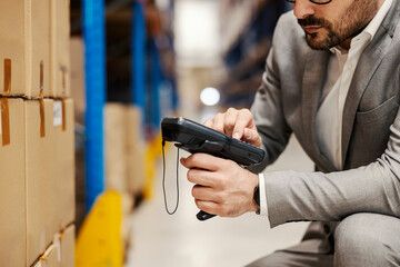 Close up of a supervisor using scanner in warehouse.