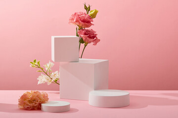 A front view of white podium decorated with flower and pink background with blank space for advertising 