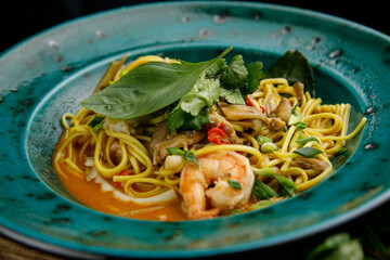 Thai food, noodles in a plate on a wooden table

