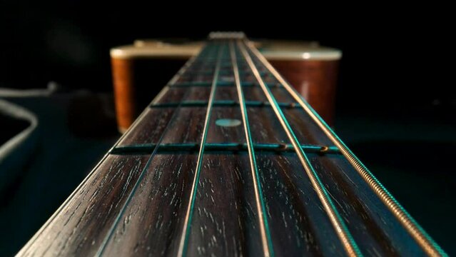 Acoustic guitar fretboard macro closeup slider shot