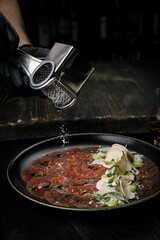 Italian cuisine, tartar with parmesan on a wooden table
