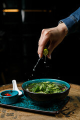 soup with lemon and herbs on a wooden table
