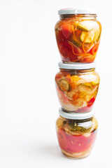 Fototapeta na wymiar Homemade canned various vegetables with spices in glass round jars