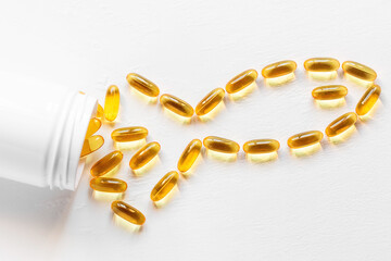 jar with omega 3 capsules in the shape of a fish on a white background