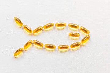 omega 3 capsules in the shape of a fish on a white background