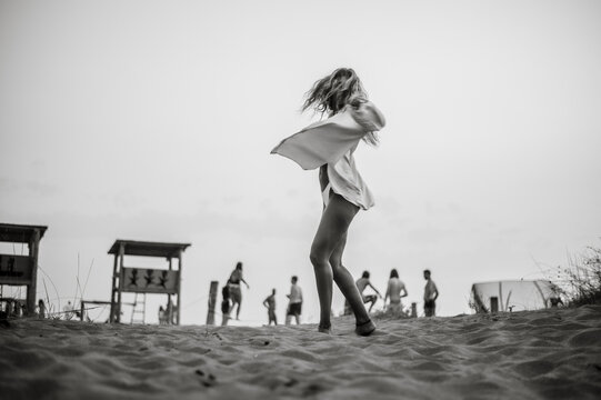 Black and white photo of a beautiful girl posing on the beach