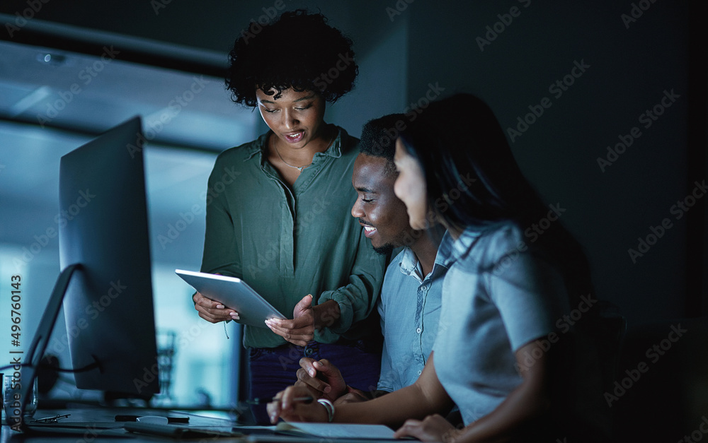 Aufkleber At the core of success is commitment. Shot of a group of young businesspeople using a digital tablet and computer during a late night at work.