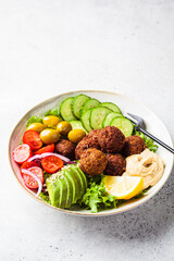 Falafel salad bowl with hummus, olives and vegetables. Healthy vegan food concept.