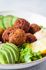 Falafel salad bowl with hummus, olives and vegetables. Healthy vegan food concept.