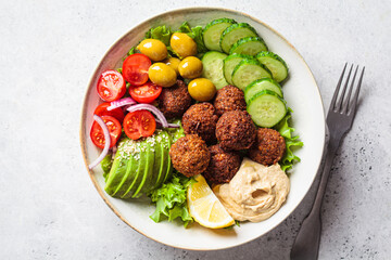 Falafel salad bowl with hummus, olives and vegetables. Healthy vegan food concept.