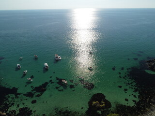 Aerial panoramic view of seascape with crystal clear azure sea and rocky shores. Yachts in a beautiful lagoon on backdrop of rocks. The concept of an ideal destination for summer travel and vacation.