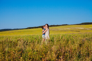 mother and son hugging in the field on a walk