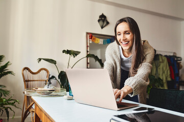 Happy freelancer working on laptop at home