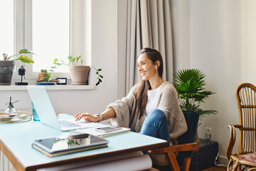 Happy freelancer working on laptop at home office
