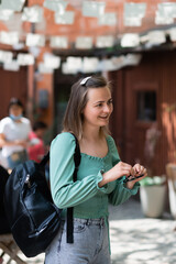 Shot of pretty young woman walking the street while holding the sunglasses