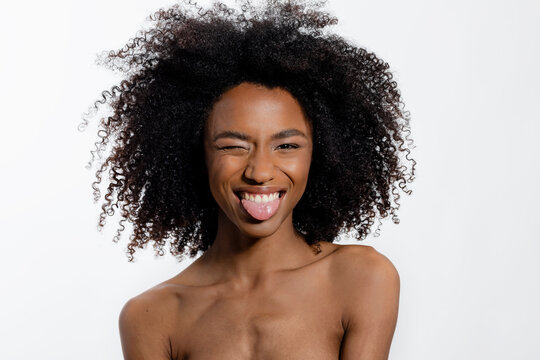 Young Woman Winking And Sticking Out Tongue Against White Background