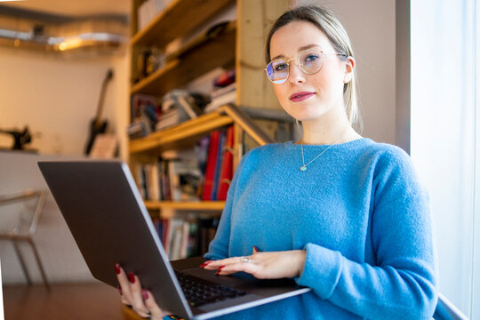 Smiling young woman with laptop