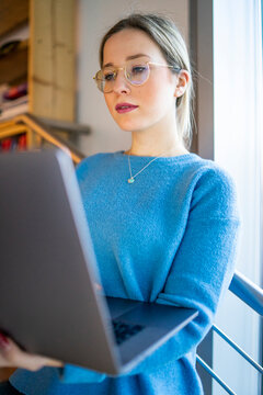 Young womanwearing eyeglasses using laptop