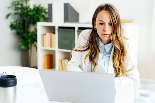 Businesswoman using laptop at desk in office