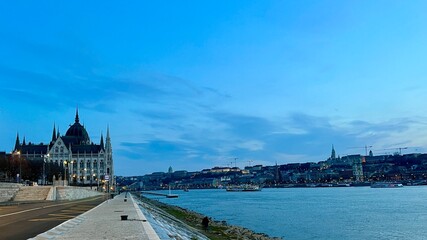 Danube River with a ship in the evening flies a lot of crows and pigeons in the distance bridge in the evening very beautiful all in blue 03.04.22 Danube Hungary. High quality 4k footage