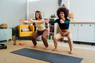 Happy women practicing squats in living room at home