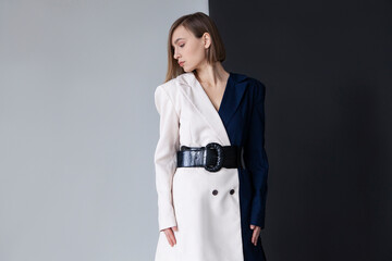 Fashionable woman standing against dual toned background