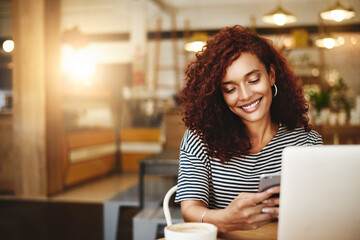 Someone just sent me another compliment about my blog. Shot of an attractive young woman using a cellphone and laptop in a cafe.