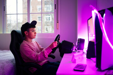 Boy playing video game on computer in bedroom at home