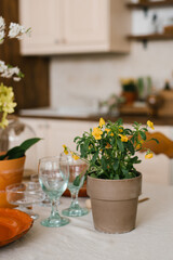 Yellow flowers in a ceramic pot in the Scandinavian-style kitchen decor