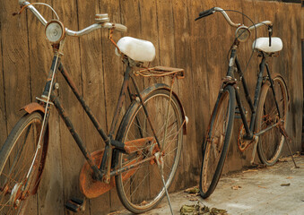 Fototapeta na wymiar Rusty old vintage bicycle near concrete wall for restaurant and hotel decoration.