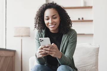 Young woman using smartphone at home. Student girl texting on mobile phone in her room. Communication, home work or study, connection, mobile apps, technology, lifestyle concept